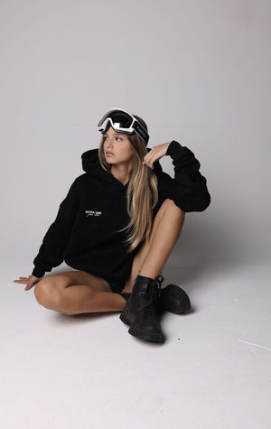 _christina_bliss_  sitting, wearing INTRA ONE's signature hoodie in black