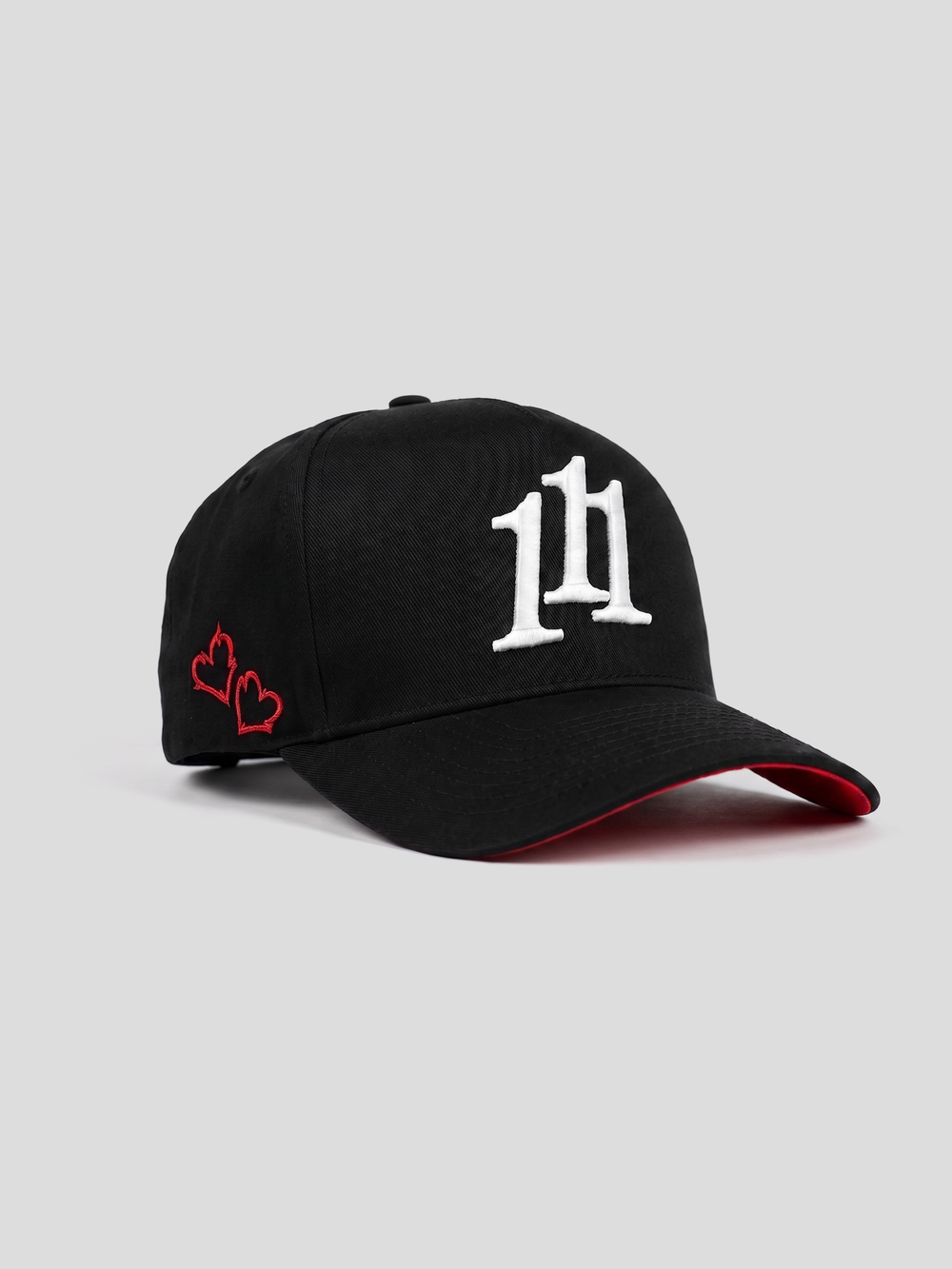 INTRA ONE's black 5 panel cap with 111 angel number logo symbol on it, with 2 small embroidered hearts and a red underbrim