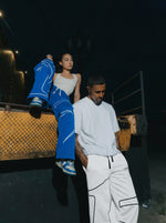Male and female model wearing INTRA ONE signature sweats in blue and white, posing at night for a streetwear fashion shoot